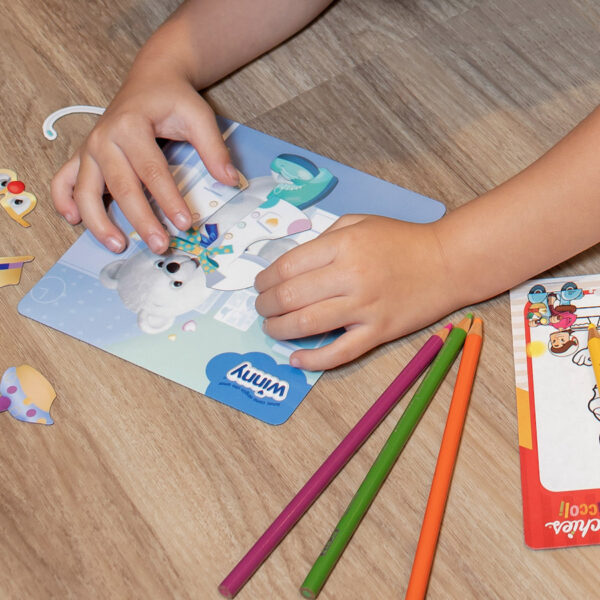 Niño jugando con el juego magnético Arma tu cuento de osito Winny, colocando fichas sobre un tablero imantado.